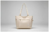Beige tote bag on denim jacket with phone and clear glass bottle