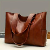 Brown leather tote bag on a light gray background