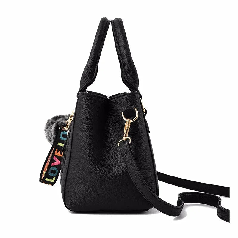 Black handbag with colorful 'LOVE' detail on a white background