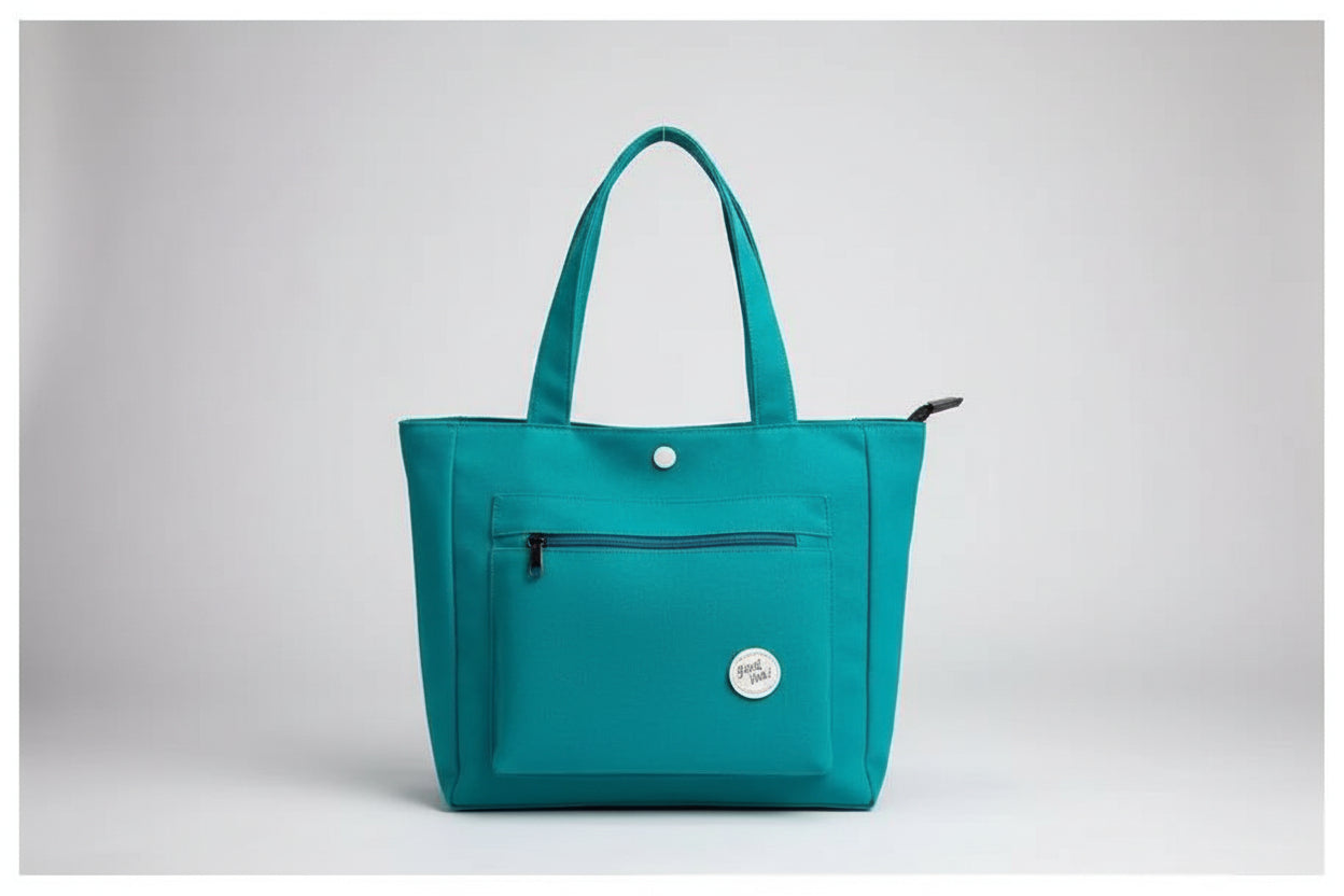 Green jacket and teal bag on a white surface with denim jacket and glass of water.