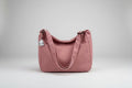 Pink corduroy bag with a patch on a bed