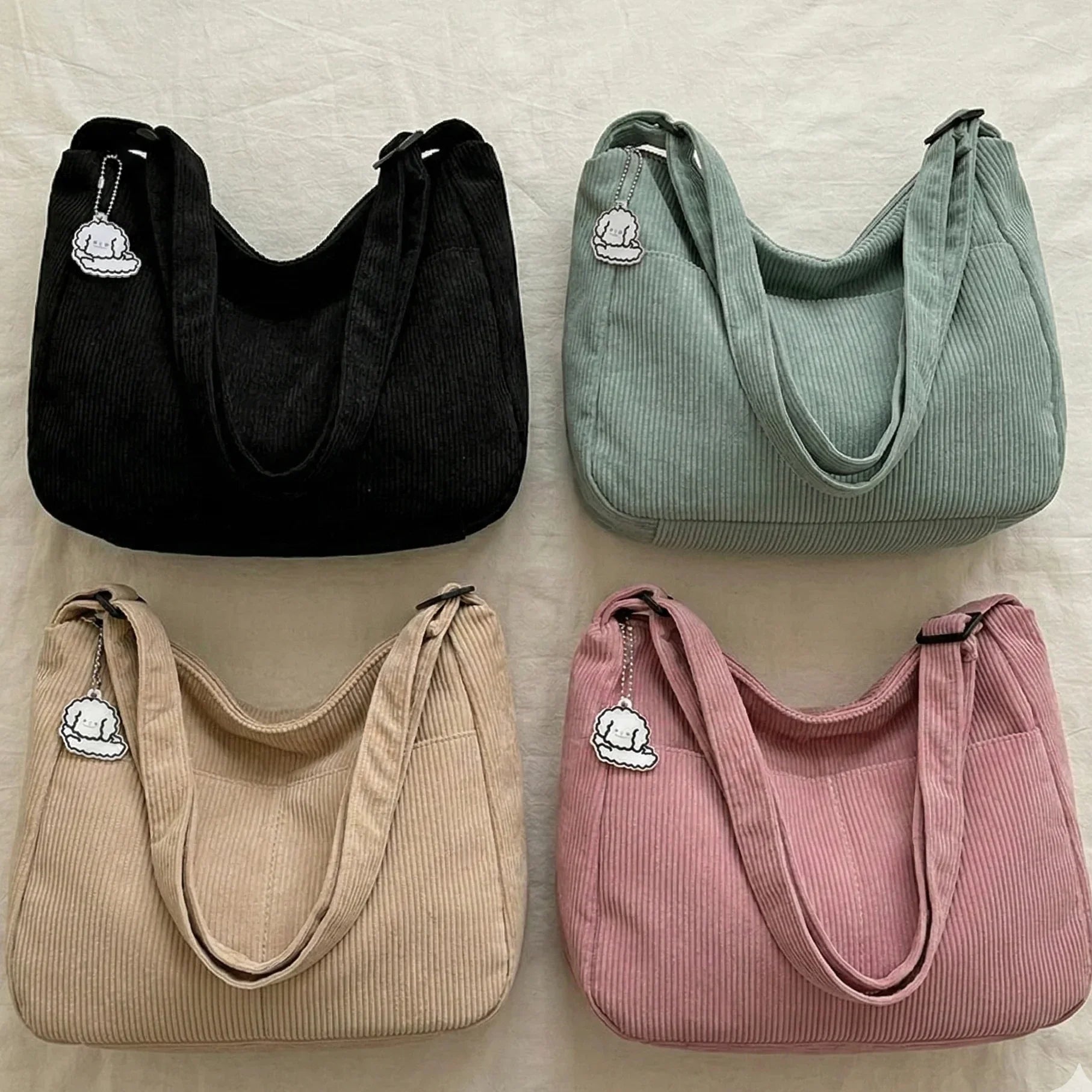 Four handbags in black, green, beige, and pink on a light background