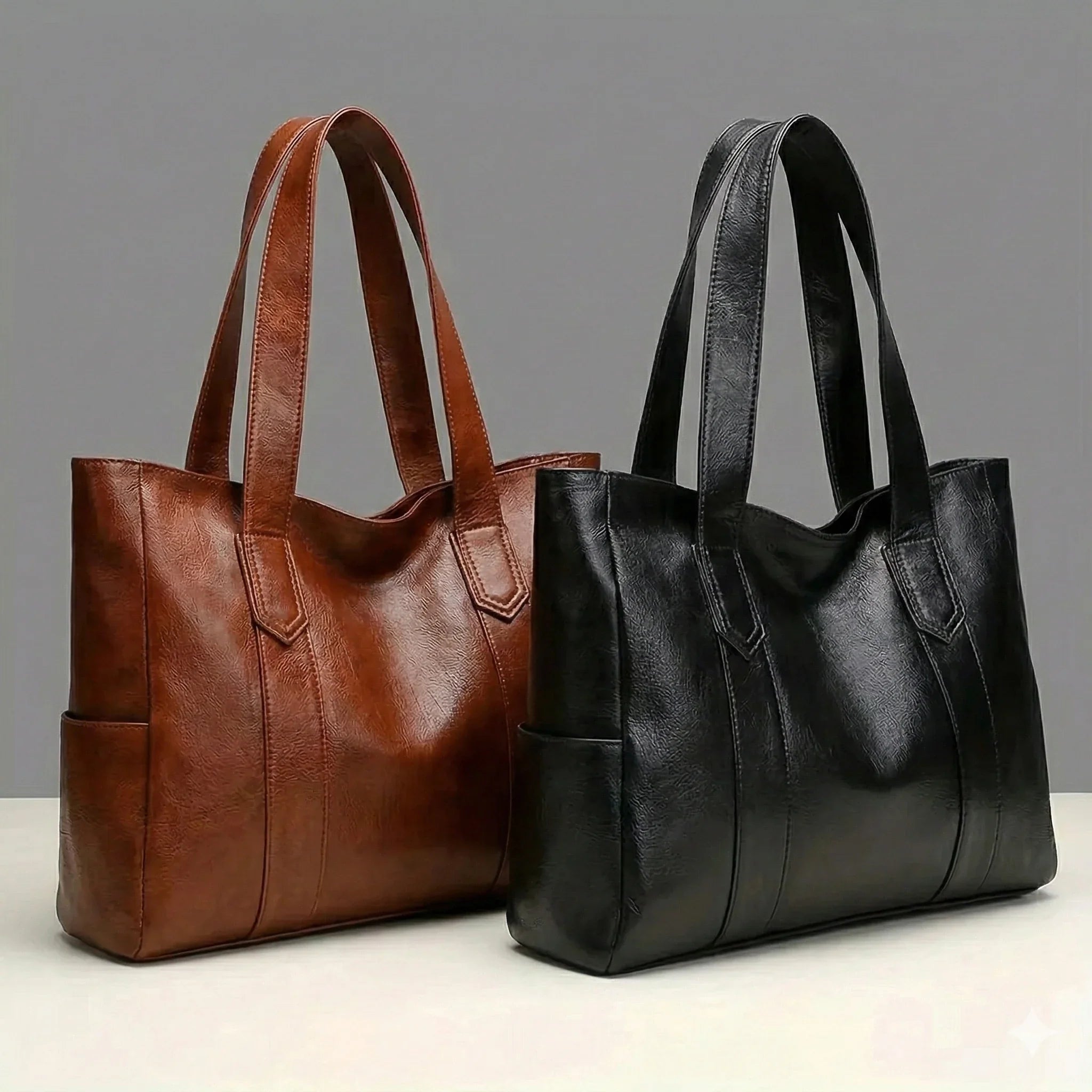 Brown and black leather handbags on a gray background