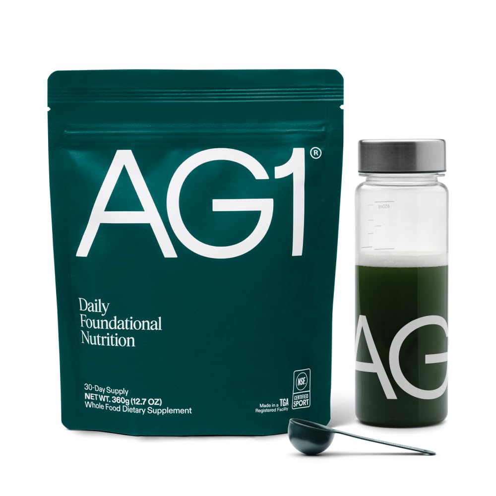 AG1 supplement package with a bottle and scoop on a white background