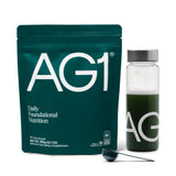 AG1 supplement package with a bottle and scoop on a white background